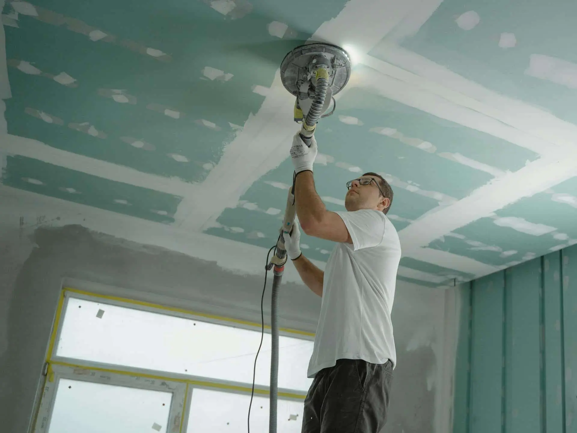 man sanding drywall